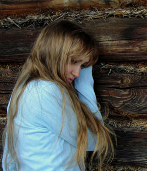 depressed young woman leaning on wall